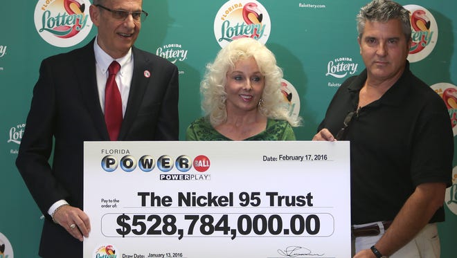 Florida Lottery Secretary Tom Delacenserie, left, presents Maureen Smith and David Kaltschmidt with their one-third share of the Jan. 13, world record Powerball jackpot Wednesday, Feb. 17, 2016, in Tallahassee, Fla. John and Lisa Robertson of Munford, Tenn., cashed in their ticket last month, also taking the lump sum. The winners in California have not publicly come forward yet.