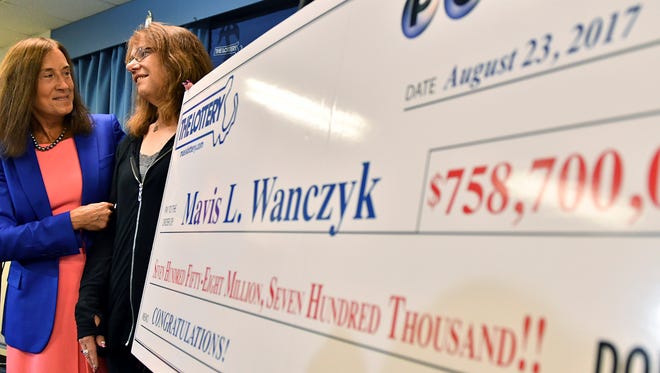 Mavis Wanczyk, of Chicopee, Mass., stands with state treasurer Deb Goldberg, left, during a news conference where she claimed the $758.7 million Powerball prize at Massachusetts State Lottery headquarters, Thursday, Aug. 24, 2017, in Braintree, Mass. Officials said it is the largest single-ticket Powerball prize in U.S. history. \(AP Photo/Josh Reynolds)