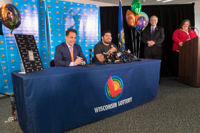 Manuel Franco, seated at table right, speaks at the news conference. With him is his attorney, Andrew Stoltmann, left,  Secretary of Revenue Peter Barca and Wisconsin Lottery Director Cindy Polzin.